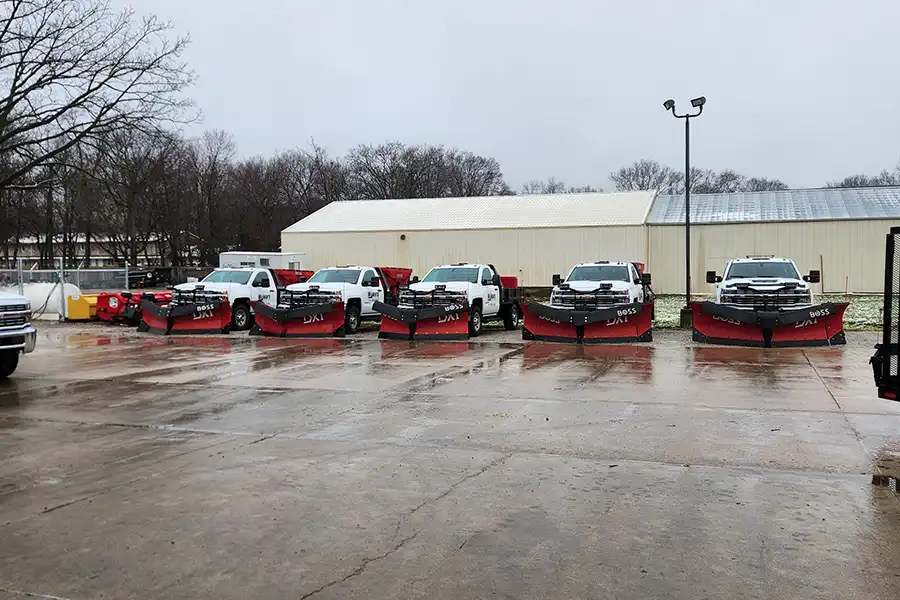 A row of commercial snow plowing trucks, owned by Wellman’s Lawn Care.